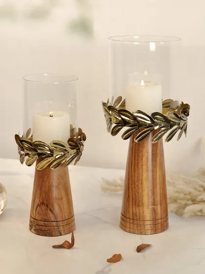 A pair of wooden and metal candle holders with lit candles. The warm glow of the flame adds life to the shot and highlights the product's primary function.