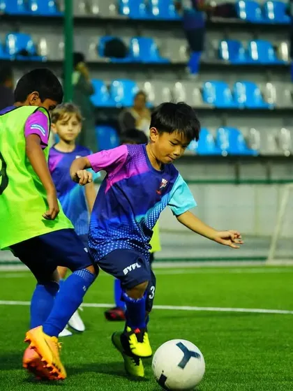 Two players battle for possession of the ball, demonstrating the competitive spirit we foster at the academy.