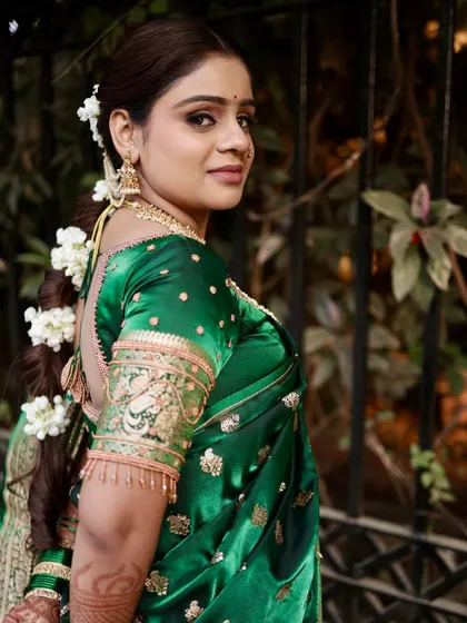 A back view showcasing the elegant braided hairstyle adorned with fresh gajra, a classic choice for Maharashtrian brides that adds fragrance and beauty.