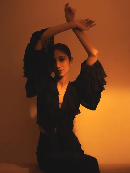 Using the arms to frame the face, this shot is all about form and silhouette. The warm lighting and dark clothing create a beautiful, high-contrast image.