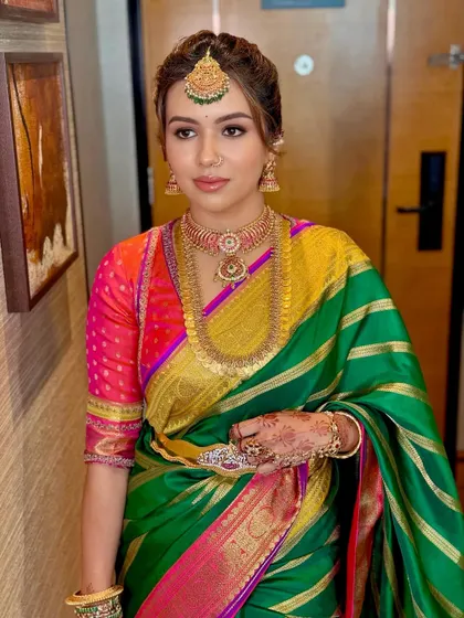 The rich colors of Deeksha's outfit are balanced with a makeup look that is both defined and elegant.