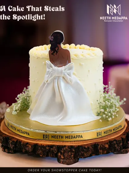 A cake that steals the spotlight. This elegant creation features a beautiful, handcrafted sugar figure of a bride in her wedding dress, making it a stunning and personalized centerpiece for a bridal shower or engagement party.