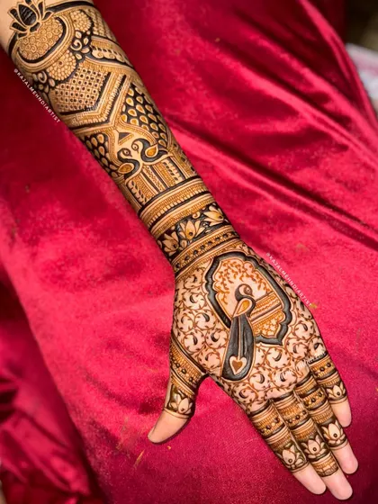 A full-hand Indian henna design featuring a central peacock, geometric patterns, and lotus motifs.