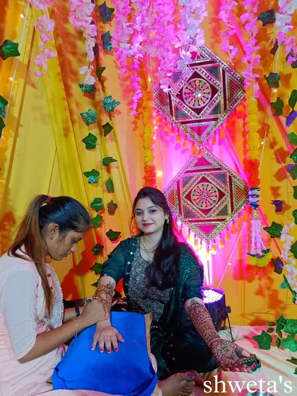 The mehendi ceremony is all about creating beautiful memories. Here I am, applying henna to a bride in a beautifully decorated setting, making her day extra special.