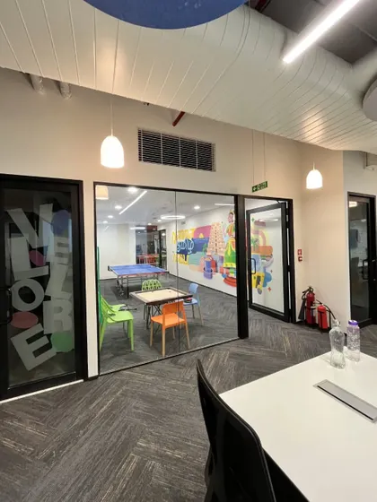 The game room at the Kissflow office, seen through a glass partition. The space is equipped with a ping-pong table and carrom board, providing employees with a dedicated zone for fun and games.