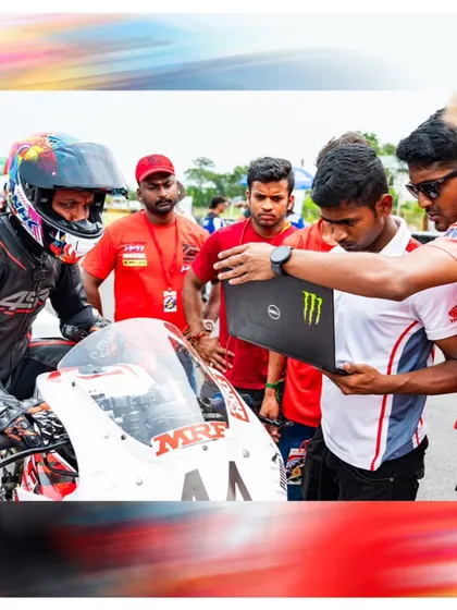 In the pits, data is everything. Here, our team analyzes lap data with a rider to find areas for improvement. This technical approach is key to our success.