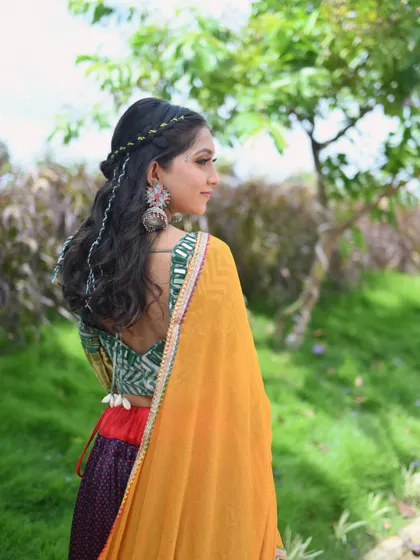 A profile shot showing the intricate details of the hairstyle and jewelry that complete the traditional Garba look. It's all about celebrating our rich heritage.