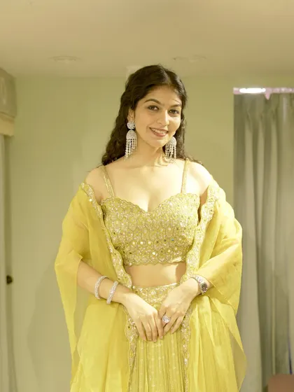 This vibrant yellow lehenga is the perfect example of a look I would curate for a Haldi or Mehendi ceremony. I focus on finding outfits with beautiful details, like the mirror work on this blouse, that make you shine at any celebration.