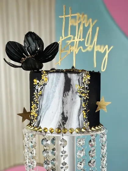 Pure elegance. This breathtaking black and gold chandelier cake is a true masterpiece, designed to be the luxurious centerpiece of a grand celebration.