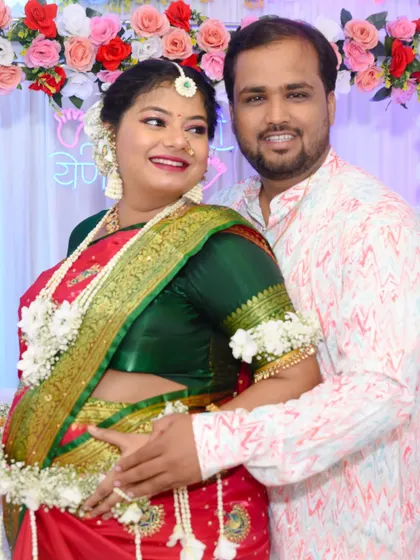 A close-up portrait of the couple, capturing the mom-to-be's beautiful smile and traditional attire.