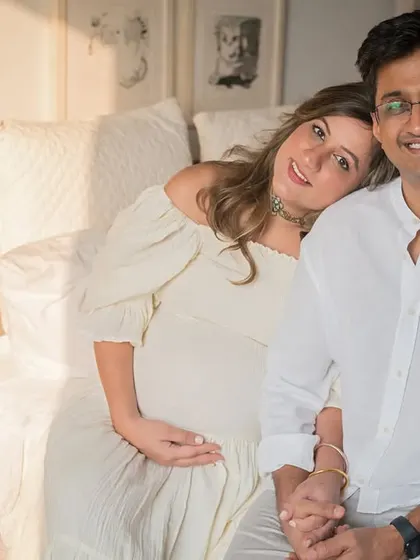 A sweet and simple portrait of the expecting couple in their bedroom. The soft morning light and their relaxed posture create a feeling of intimacy and comfort.