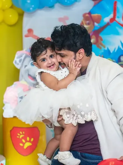 A tender moment between a father and his daughter at her Paw Patrol-themed first birthday party. These sweet, candid embraces are what family celebrations are all about.