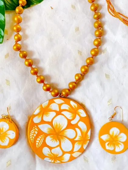 This hand-painted floral set features a bright, cheerful design on a round pendant. Such floral motifs have universal appeal and are a staple for any jewelry reseller.