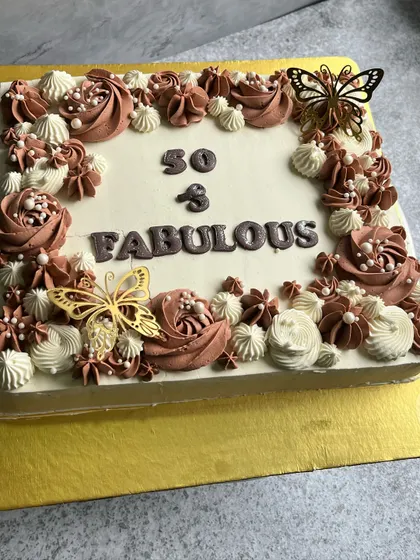 Fifty and fabulous. This large square cake is perfect for a big celebration, decorated with beautiful buttercream rosettes in shades of chocolate and cream, and elegant butterfly toppers.