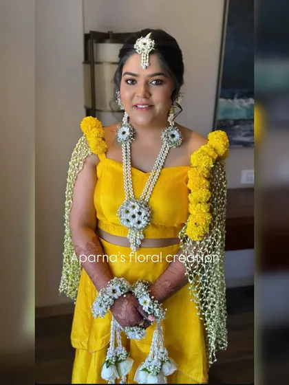 For a Haldi ceremony, bright and happy colors are a must. I created this stunning floral set with vibrant yellow flowers and baby's breath, including unique floral sleeves (bajuband) that drape over the shoulders for a truly special look.
