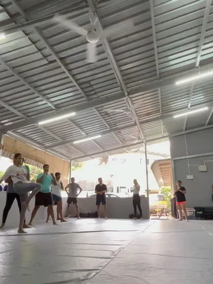 A wide shot of the class practicing kicks, showing the space and the energy.