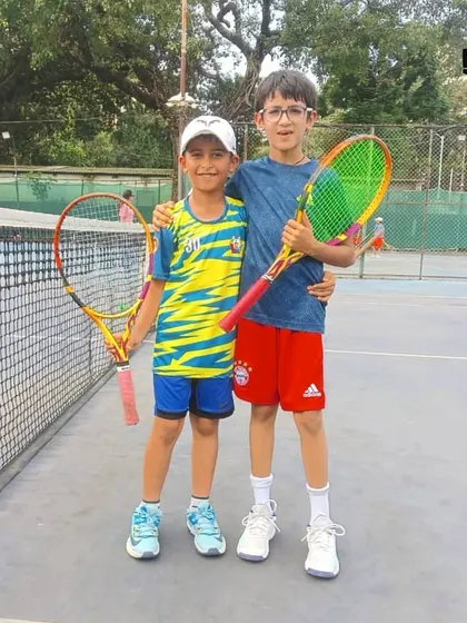Two young players, rackets in hand, embodying the friendship and sportsmanship we foster at our tournaments.