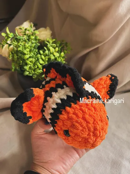 Just like Nemo! This handmade clownfish toy is crafted with vibrant orange, black, and white yarn. It's a soft and cuddly friend for any fan of underwater creatures.