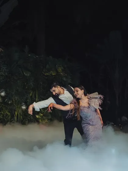 A romantic dance in the mist. The couple shares a moment on the dance floor, surrounded by low-lying fog for a dreamy effect.