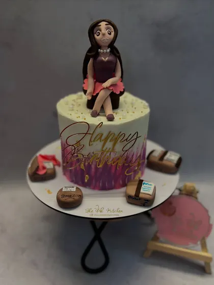 A full view of the shopaholic-themed cake, showing the hand-painted watercolor buttercream finish and the little edible shopping boxes surrounding the custom-made fondant figure.