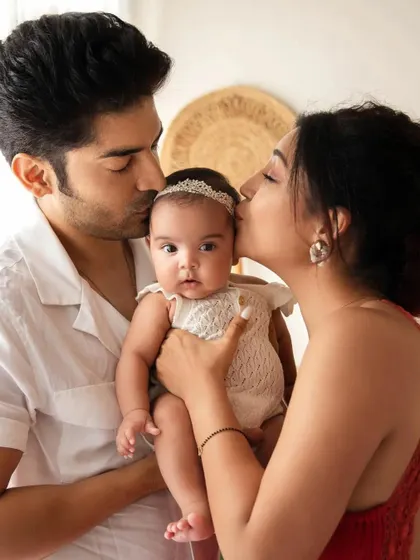 Actress Debina Bonnerjee and her husband Gurmeet Choudhary kiss their baby girl Lianna. A heartwarming family portrait celebrating their new daughter.