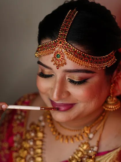 The final touch. Applying lipstick is a key step that brings the entire look together. This is an unfiltered, behind-the-scenes shot.