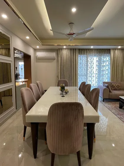 This image captures the complete open-plan living and dining area, showing the seamless transition between the two zones. The consistent color palette and material choices create a harmonious and expansive feel.