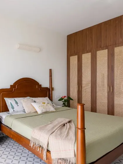 Another angle of the bedroom, showcasing the beautiful four-poster bed and the warm, earthy tones of the wicker wardrobe.