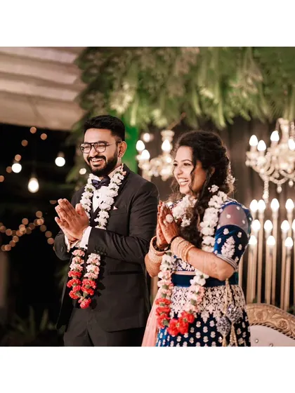 A classic reception portrait of the couple, their happy smiles and traditional garlands showing their joy.