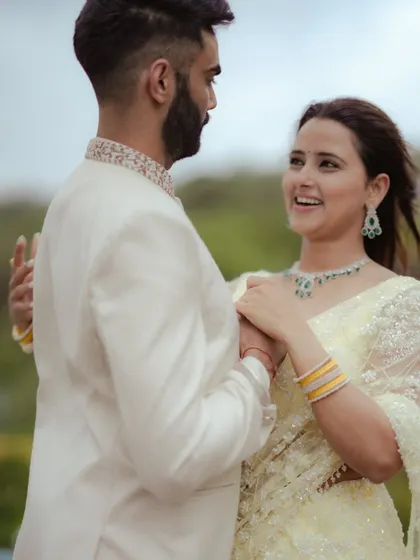A candid moment of affection during an outdoor pre-wedding shoot. The natural setting adds a soft, romantic feel.