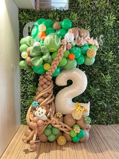 A playful jungle-themed balloon bouquet for a 2nd birthday, featuring a monkey, a giraffe, and a lush green tree.