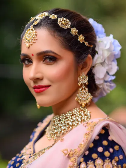 This Kundan jewelry set is perfect for a royal-themed event. The set includes a statement choker, long earrings, and a delicate matha patti, paired here with a navy blue velvet lehenga for a rich, elegant look.