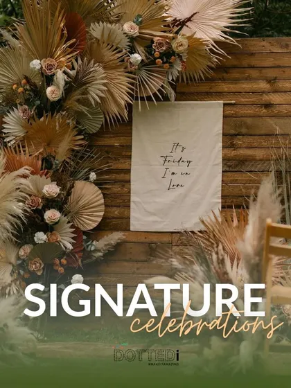 A signature boho-chic setup against a rustic wooden wall. The arrangement of dried pampas grass, palm leaves, and fresh flowers creates a stunning, textural backdrop.