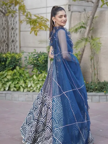 The back view of the navy and white lehenga, showing the delicate, ruffled dupatta and the continuation of the bold geometric pattern.
