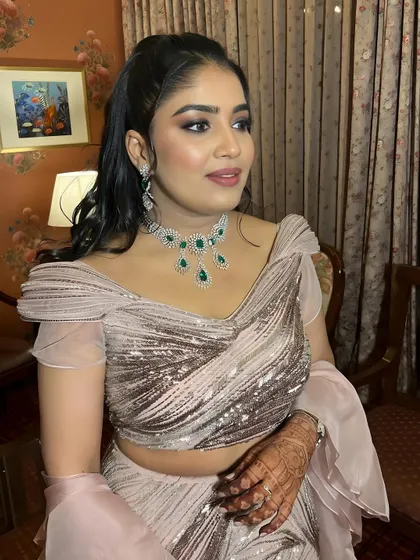 A close-up portrait showing the details of the eye makeup and the beautiful emerald jewelry.