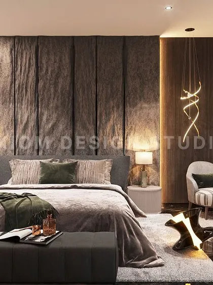 This modern luxury bedroom exudes bold character, with a dramatic textured stone bed back, a comfortable seating nook, and statement art.