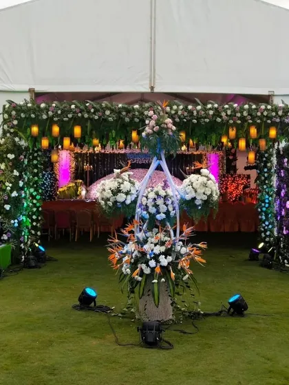 Another angle of the grand entrance to the wedding tent, with traditional statues and floral arrangements.