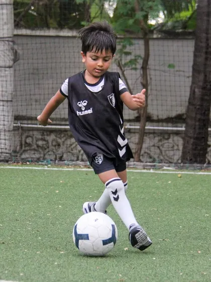 A player in our black training bib practices a close-control dribble, essential for protecting the ball from opponents.