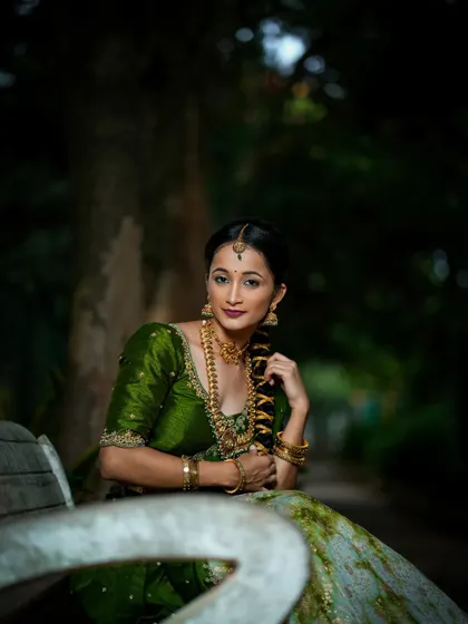 A serene portrait of a client in her custom green and white half saree.