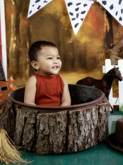 A happy smile from inside a rustic log prop. I use a variety of props to keep babies engaged and get those great shots.
