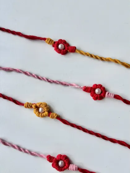 A closer look at the handmade flower Rakhis, showing the different color combinations of red, pink, and yellow.