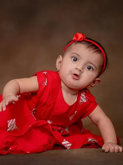 Cuteness overload. Her curious expression and bright red dress make for a lovely portrait.