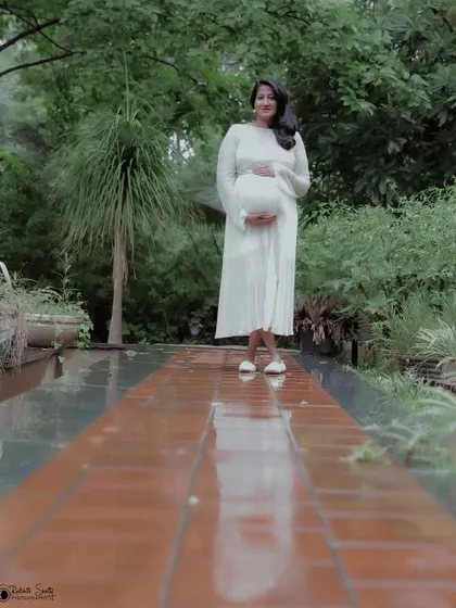 A full-body portrait that emphasizes the journey of motherhood. The long pathway symbolizes the path ahead, captured on a tranquil, rainy day.