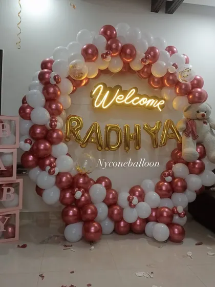 Bringing your baby home is a moment to cherish. I can prepare a beautiful 'Welcome Home' decoration at your place, like this personalized ring backdrop for 'Welcome RADHYA' with a cute teddy bear.