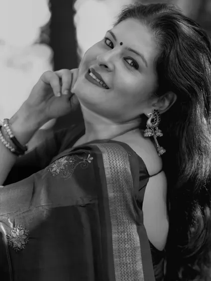 A smiling black and white portrait in an embroidered saree. This captures a moment of pure happiness and confidence.