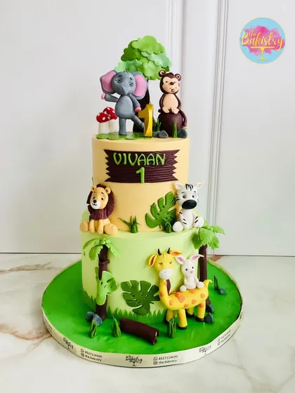 Another jungle adventure! This two-tiered cake for Vivaan's first birthday is filled with friendly animals like an elephant, monkey, lion, and giraffe.
