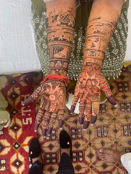 A full story on both arms. This bridal mehndi includes family portraits, wedding ceremony scenes, and traditional symbols, creating a complete narrative.