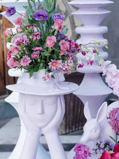 Whimsical sculptures, like this lady with a floral hat, added a unique and artistic touch to the Victorian garden theme.