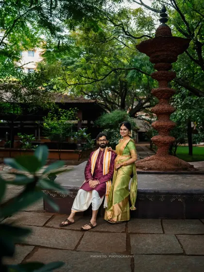 A formal portrait of the couple seated by a traditional lamp post, blending cultural attire with the serene ambiance of the venue.