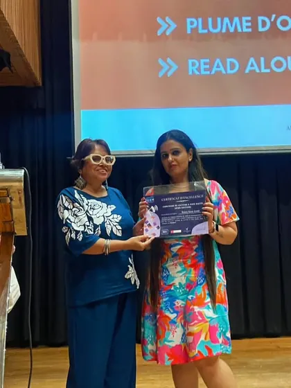 A student receives her award certificate on stage during our Bastille Day celebrations. We publicly recognize and honour the winners of various competitions like Défi Inter-Alliances and Read Aloud.
